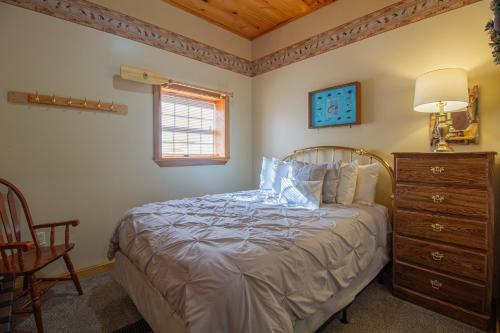 a bedroom with a bed and a dresser and a window at Stay In Ohiopyle - closest place to the GAP trail in Ohiopyle, PA, Hot Tub in Ohiopyle
