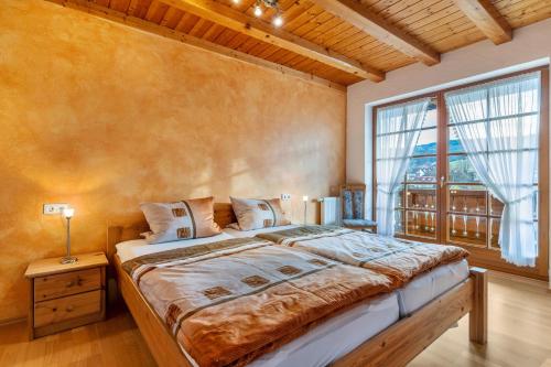 a bedroom with a large bed and a large window at Wanglerhof Familie Wangler in Schuttertal