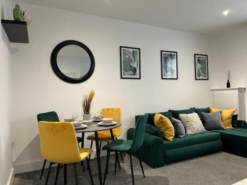 a living room with a green couch and a table at City Centre 2 Bed - Long Stay Offer - Sleeps 6 in Strood