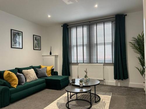 a living room with a green couch and a table at City Centre 2 Bed - Long Stay Offer - Sleeps 6 in Strood
