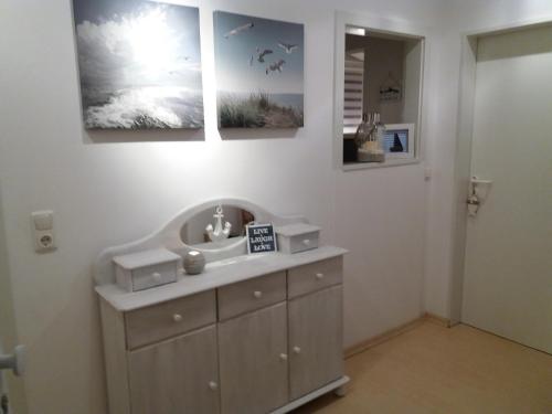 baño con lavabo y 2 cuadros en la pared en Liegeplatz 24, en Tönning