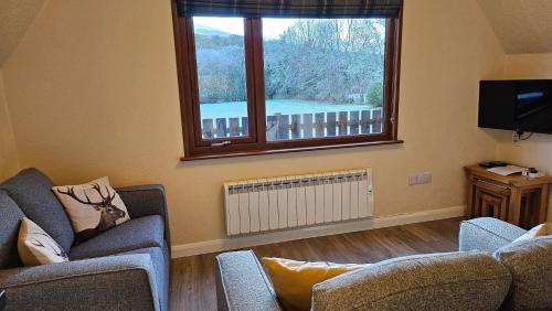 a living room with two chairs and a window at Bunroy Park in Fort William