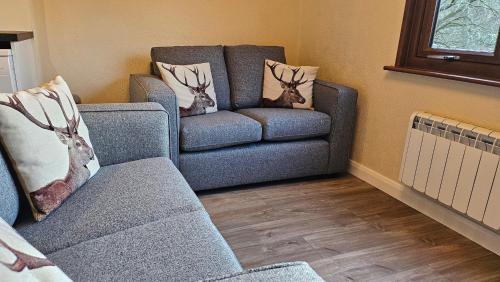 a living room with a couch and a chair at Bunroy Park in Fort William