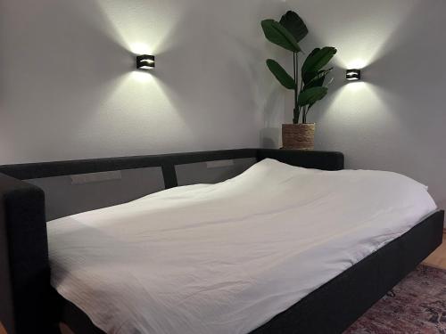 a bed with two lights and a potted plant at Appartement 413 Kunners Oostenrijk in Mittelberg
