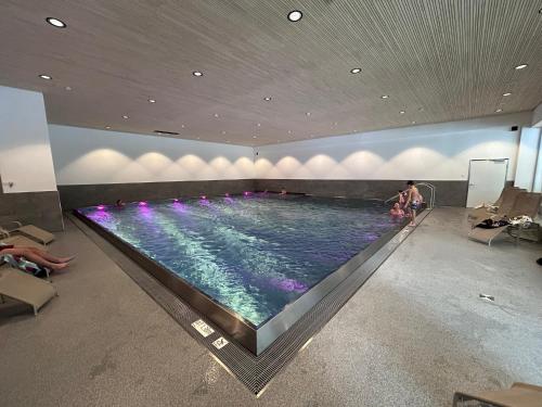 a large swimming pool in a building with people in it at Appartement 413 Kunners Oostenrijk in Mittelberg