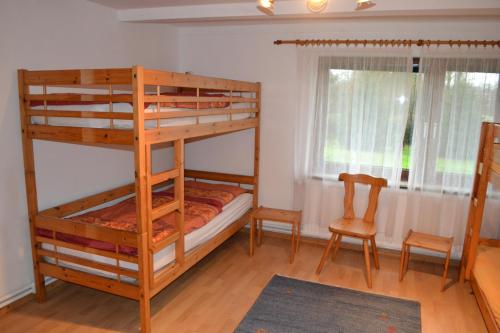 a bedroom with two bunk beds and a chair at EG Inge in Katharinenheerd