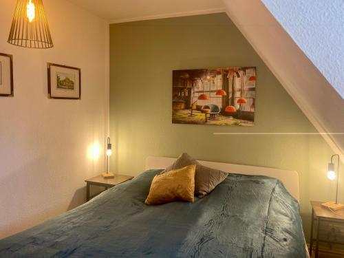 1 dormitorio con 1 cama y una pintura en la pared en Nordlicht, en Vollerwiek