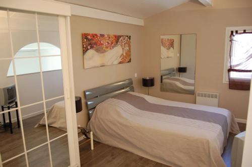 une chambre avec un lit et un miroir dans l'établissement Village naturiste - Cap sauvage - Villa les lauriers, au Cap d'Agde