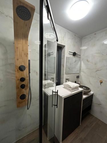 een badkamer met een douche en een glazen achterdeur bij REST ZONE - mountain holiday chalets in Ściegny