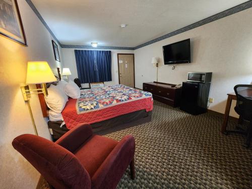 a hotel room with a bed and a television at Americas Inn Bardstown in Bardstown