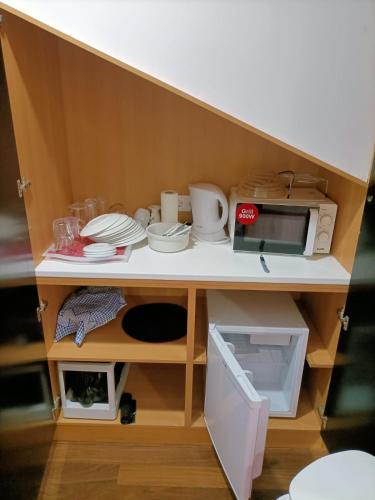 a toy kitchen with a counter with dishes and a microwave at O Cantinho do Arnaldo in Viana do Castelo