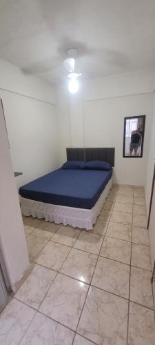 a bedroom with a bed in a room with a tile floor at Maravilhosa Kitnet 10 min da praia in Vila Velha