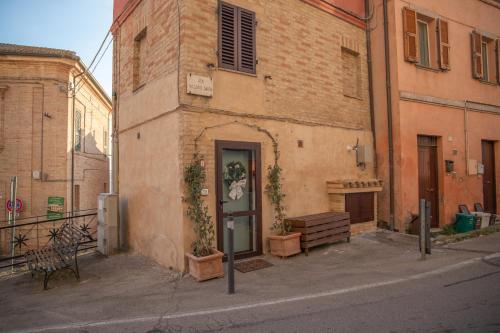 an old brick building with a door on a street at La Casetta. Feel at home. in Castelfidardo