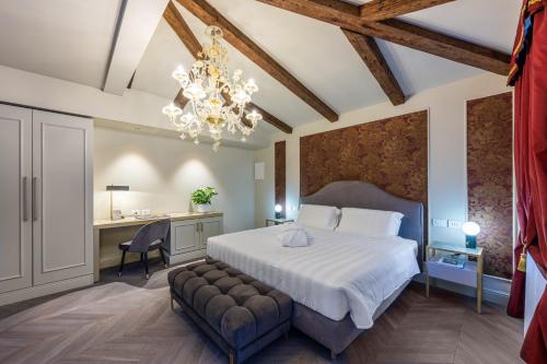 a bedroom with a bed and a desk and a chandelier at Palazzina Sardi in Venice