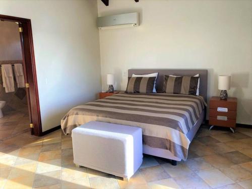 a bedroom with a bed and a stool in it at Beach Villa Casa del Mar in Kralendijk