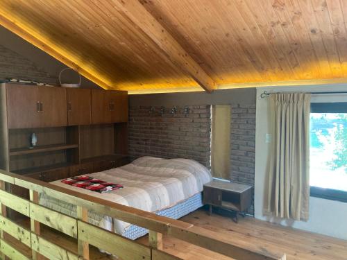 a bed in a room with a wooden ceiling at Casa de Montaña Uspallata, Mendoza in Estación Uspallata