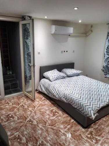 ein Schlafzimmer mit einem Bett und einem Spiegel auf dem Boden in der Unterkunft Appartement avec terrain in Pézenas