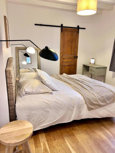 - une chambre avec un lit, une table et une lampe dans l'établissement Le Jeanne, appartement en duplex proche forteresse et centre ville, à Chinon