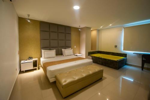 a bedroom with a large bed and a tub in it at Infinity Hotel in Medellín