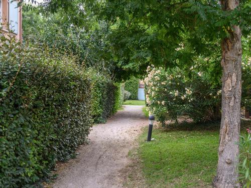 a path with a parking meter next to a hedge at Vacanceole - Residence les Demeures du Ventoux in Aubignan
