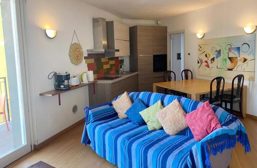 salon z niebieską kanapą i kolorowymi poduszkami w obiekcie The Duplex - Big Apartment with Terraces w mieście Argegno