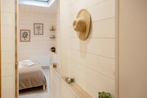 una camera con un letto e un cappello sul muro di Atlantic Selection - Un séjour à la Villa Sharon avec terrasse et parking a Capbreton
