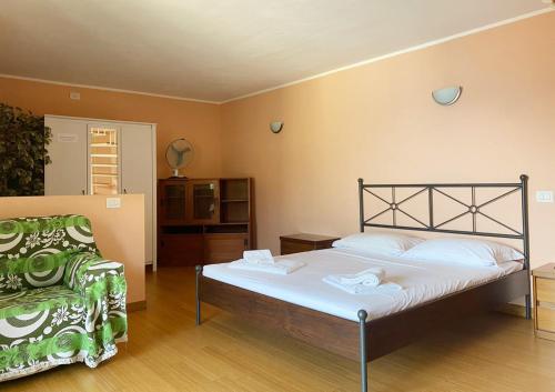sypialnia z łóżkiem i krzesłem w obiekcie The Duplex - Big Apartment with Terraces w mieście Argegno