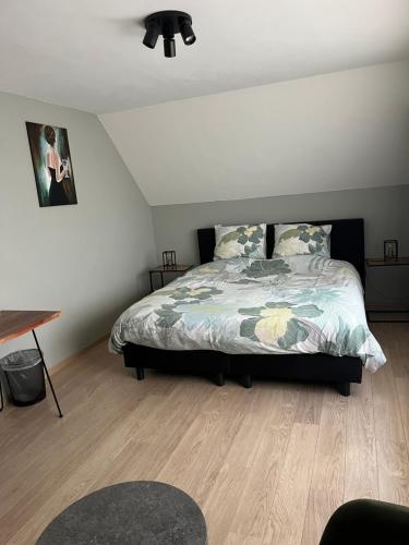 um quarto com uma cama e piso em madeira em Hazegewoud em Arendonk