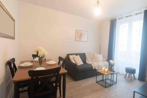 una sala de estar con un sofá y una mesa en Le Parisien-Clichy-2 pièces Zen, en Clichy