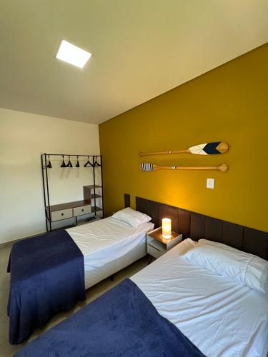 Duas camas num quarto com paredes amarelas em Casa Beija-Flor em Paraty