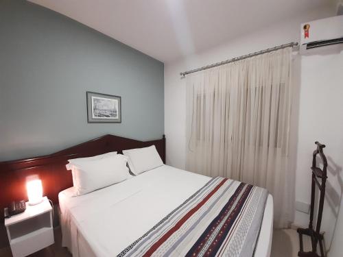 um quarto com uma cama branca e uma janela em INCRIVEL Flat proximo Shoppings JK e Vila Olimpia em São Paulo