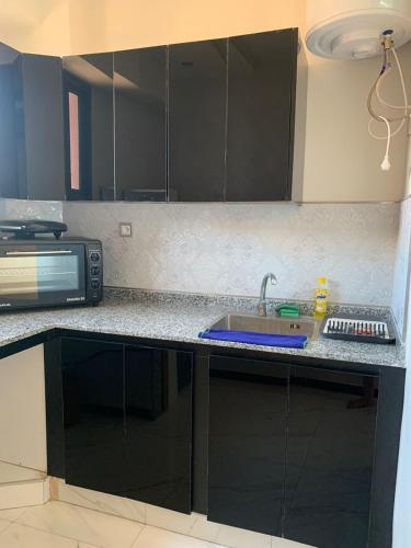 een keuken met een wastafel en een magnetron bij Appartement zyad in Marrakesh