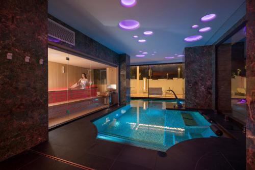 a bathroom with a swimming pool with a person in the bathtub at The Promenade Luxury Wellness Hotel in Riccione