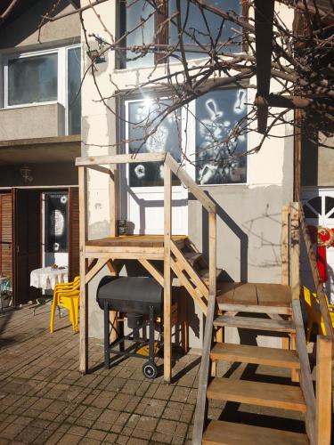 a wooden ladder and a chair in front of a building at Аpartman ELENA in Rakovac