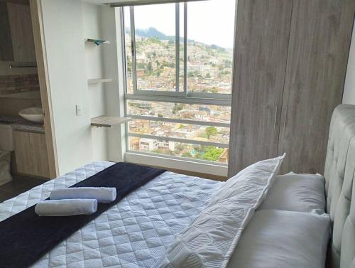 een slaapkamer met een bed en een groot raam bij Vista Paradisíaca, Centro Histórico de Bogotá in Bogota