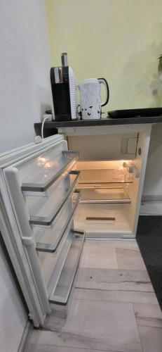 an empty refrigerator with its door open in a room at Yoga Atelier Vaihingen Enz in Vaihingen an der Enz