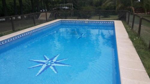 uma grande piscina azul com duas estrelas em CARELHUE ZARATE em Zárate