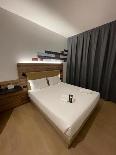 1 dormitorio con 1 cama con reloj en B&B HOTEL Prato City Center, en Prato