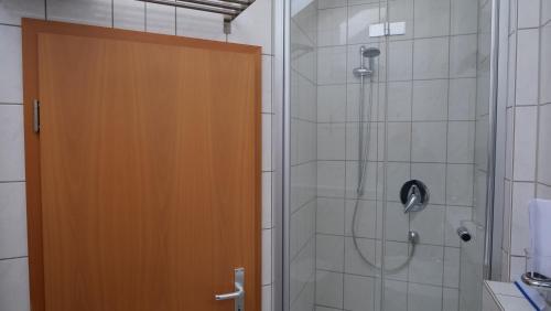 een douche met een houten deur in de badkamer bij Ferienwohnung Rhein-Panorama in Lahnstein