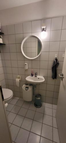 a bathroom with a sink and a toilet and a mirror at Yoga Atelier Vaihingen Enz in Vaihingen an der Enz