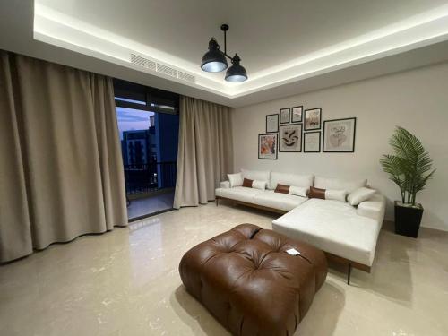 sala de estar con sofá y reposapiés en Access - luxurious apartment at cfc, en El Cairo