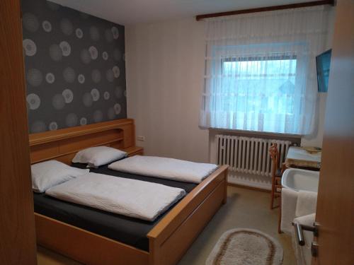 a small bedroom with two beds and a window at Ferienhaus Seifert in Bischofsheim an der Rhön