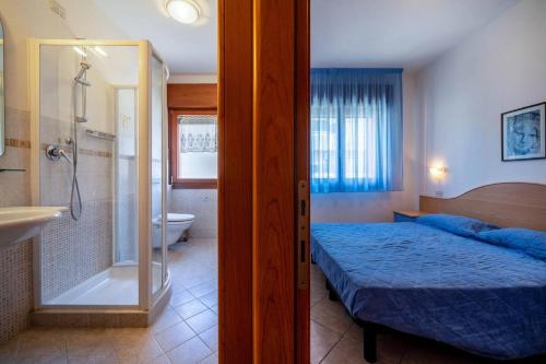 a bedroom with a bed and a shower and a bathroom at Residence Guardamar - Agenzia Cocal in Caorle