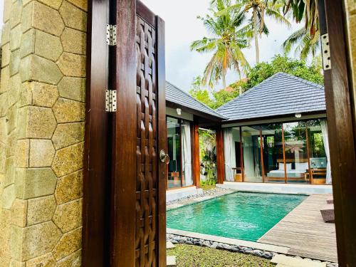 une porte ouverte menant à une maison avec une piscine dans l'établissement Wana Karsa The Villas Ubud, à Ubud