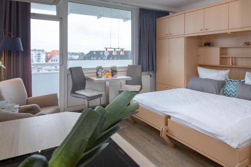 - une chambre avec un lit, un bureau et une table dans l'établissement Ferienwohnung mitten in Westerland mit Balkon, à Westerland