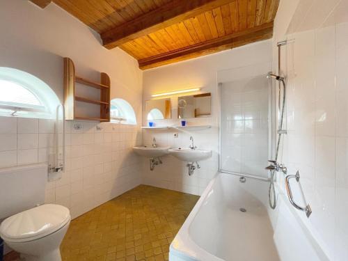 a bathroom with a tub and a toilet and a sink at Haus-Wolfram-App-Wilhelmine in Morsum