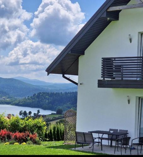 a patio with a table and chairs and a view at ,,KICZARA" Pokoje nad Jeziorem Solińskińskim w Polańczyku, 601-806-454 przy Tarasie Widokowym in Polańczyk