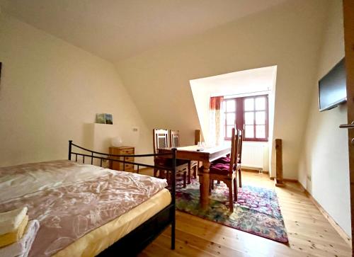 a bedroom with a bed and a desk and a window at Pension am Markt Meißen in Meißen