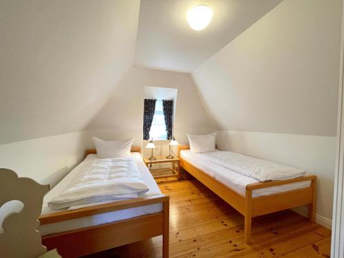 a bedroom with two beds in a attic at Reetdachhäuschen Lütt in Kampen in Kampen