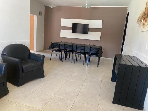 ein Esszimmer mit einem Tisch, Stühlen und einem TV in der Unterkunft Casa Villa Carlos Paz, a 3 cuadras del río. Playas de Oro in Villa Carlos Paz
